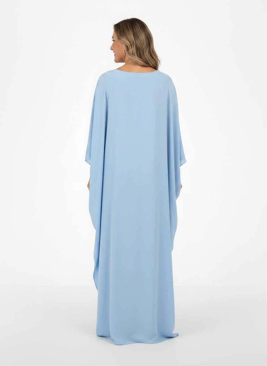 Back pose of the model wearing Robe maxi avec cape femme